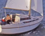 Un voilier Evasion 22 navigue sur une mer agitée, deux personnes à bord profitent de la brise.