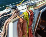 Sur un voilier, la différence entre drisse et écoute est claire : les drisses hissent les voiles, les écoutes les règlent. Ici, des cordages colorés attendent leur usage.