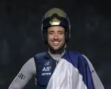 Quentin Delapierre, souriant, porte un casque de voile et une tenue de sport.