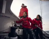 Amélie Grassi et son équipage en pleine action sur un voilier Crédit Mutuel. Le vent souffle, la mer est agitée.