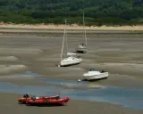 Trois voiliers et un bateau à moteur échoués sur la vase, avec un zodiac rouge au premier plan. Le **kelt 9** est l'un des voiliers.