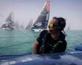 Franck Cammas, concentré, navigue en tête d'une flotte de voiliers dans le brouillard.