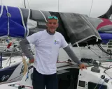 Gildas Mahé, skipper, pose sur son voilier, prêt pour une nouvelle aventure maritime.