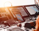 Tableau de bord d'un navire avec écrans radar et cartes maritimes. La **priorité voile** est assurée par ces technologies de navigation avancées.