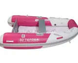 Un petit bateau gonflable rose et blanc, parfait pour rejoindre un grand bateau.