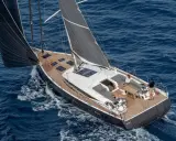 Un couple profite d'une croisière sur un voilier habitable à l'année, naviguant sur des eaux bleues par une journée ensoleillée.