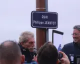 Un panneau "Quai Philippe JEANTOT" honore le navigateur. Philippe JEANTOT, entouré, parle au micro.