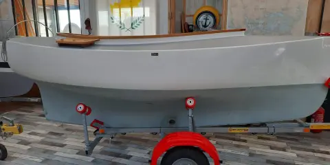 Bateau blanc sur remorque, prêt pour l'aventure. Le drapeau chypriote flotte, rappelant les eaux bleues. Un **pabouk 360** attend son prochain voyage.
