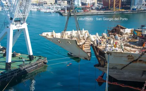 Démantèlement du Costa Concordia : une section du navire est soulevée par une grue dans un port.