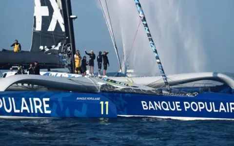 Équipe sur un trimaran Banque Populaire, rappelant l'esprit d'aventure d'un olivier de kersauson jeune.