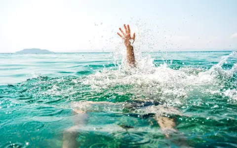 Main d'une personne émergeant de l'eau, éclaboussures vives. Un appel à l'aide pour sauver quelqu'un de la noyade.