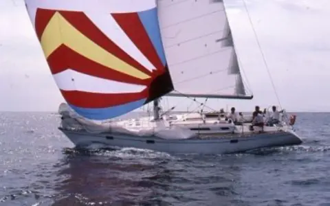 Un voilier avec une voile colorée, rappelant une légende du soleil, navigue sur une mer agitée. 41 avis sur cette aventure.