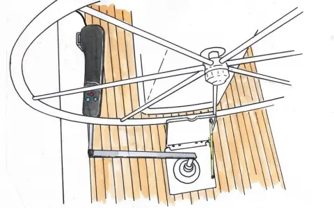 Vue rapprochée d'un système de barre à roue de bateau, avec un manche noir et des boutons bleus et rouges.