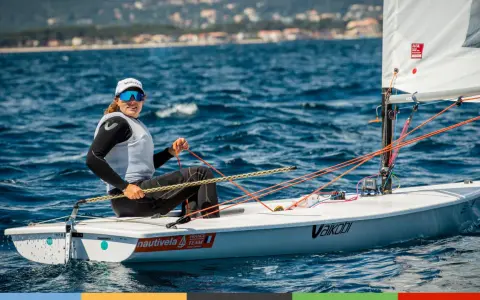 Louise Cervera, navigatrice française, manœuvre son dériveur ILCA sur une mer bleue. Elle porte une casquette et des lunettes de soleil.