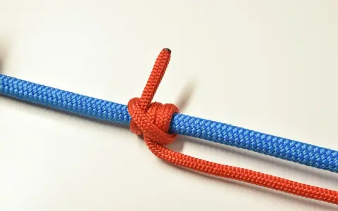 Un nœud de bosse rouge est solidement attaché à une corde bleue, prêt pour une aventure.