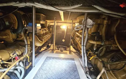Vue de la salle des machines d'un bateau, avec deux moteurs inboard jaunes. L'entretien régulier est essentiel pour la durée de vie d'un moteur inboard.