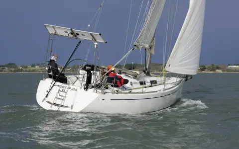 Voilier Dufour 34 en navigation, voiles blanches gonflées par le vent. La fiche technique de ce bateau est impressionnante.