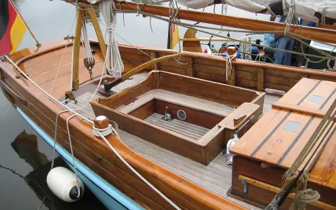 Le cockpit bateau en bois verni, avec ses cordages et sa bouée blanche, prêt pour une nouvelle aventure.