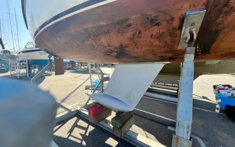 Vue du dessous d'un voilier sur bers. Le safran est visible, prêt pour l'étape 22 de la fiche technique.