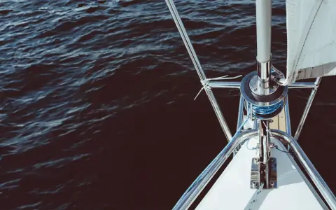 Le voile avant du bateau est prêt à être déployé sur l'eau sombre.