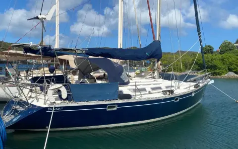 Voilier bleu "Iguana" au mouillage, sous un ciel bleu et nuageux. La magie du soleil sur l'eau, 44 avis.