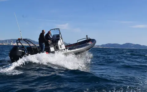 Deux hommes naviguent sur un Zodiac en Méditerranée. La météo marine méditerranée gratuite est idéale pour cette sortie en mer.