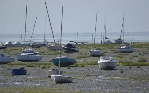 Échoués sur la vase, plusieurs voiliers et bateaux à moteur attendent la marée. Une scène typique de la fiche technique d'un port, avec des bateaux de type Edel 4.