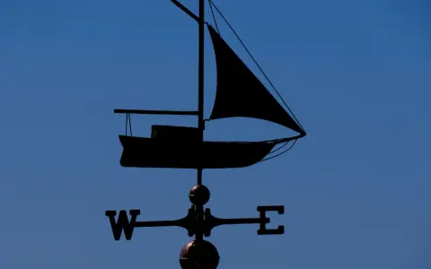 Girouette en forme de voilier, indiquant le vent. Un outil de météo IA pour naviguer.