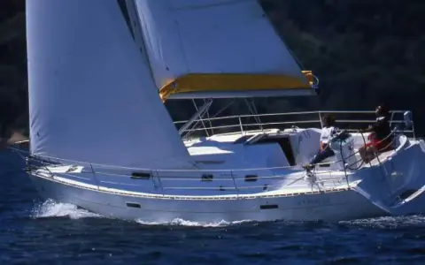 Voile blanche gonflée sur un voilier Oceanis 331 naviguant sur une mer bleue. Avis positifs pour ce bateau.