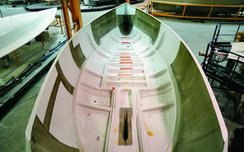 Intérieur d'une coque de bateau en construction, prêt pour le talonnage bateau. Lignes épurées et structure visible.