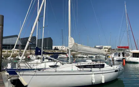 Voiliers blancs amarrés dans un port sous un ciel bleu. L'ambiance est paisible, feeling 920 avis.