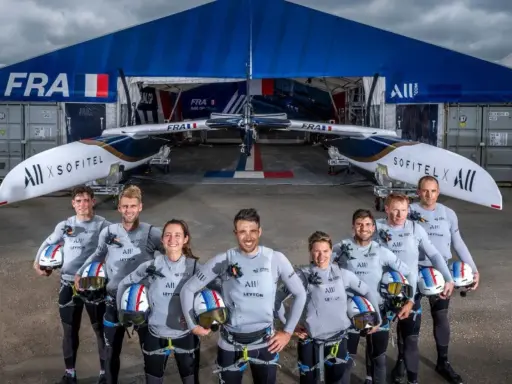 L'équipe française du SailGP France pose fièrement devant son catamaran, prête à conquérir les océans.