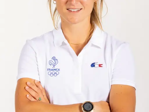 Manon Audinet, athlète française, porte un polo blanc avec les anneaux olympiques et le coq gaulois.