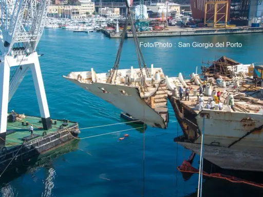 Démantèlement du Costa Concordia : une section du navire est soulevée par une grue dans un port.
