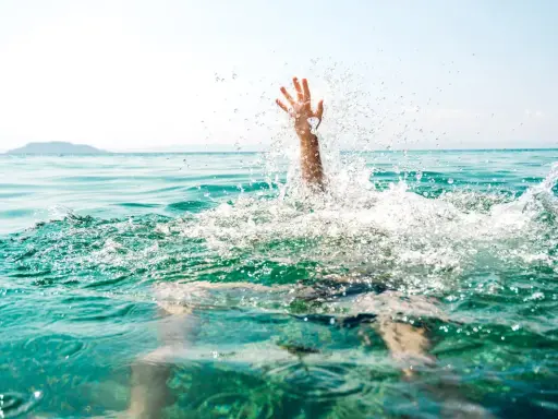 Main d'une personne émergeant de l'eau, éclaboussures vives. Un appel à l'aide pour sauver quelqu'un de la noyade.