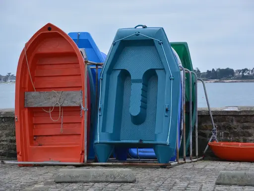 Plusieurs petites barques colorées sont rangées sur le quai, prêtes à être utilisées pour rejoindre son bateau.