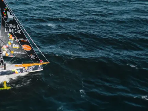 Voilier "Coup de Pouce" naviguant sur une mer agitée, avec le nom "Manuel Cousin" visible sur la voile.