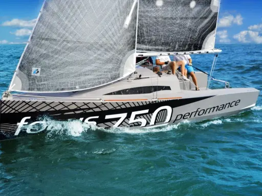 Voile du **Bepox 700** performance fendant les vagues bleues, deux navigateurs à bord.