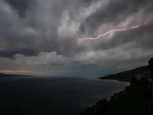 Éclair zébrant le ciel sombre au-dessus du lac Léman, annonçant une violente tempête.