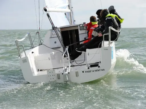 Équipage sur un voilier polonais transportable naviguant sur une mer agitée.