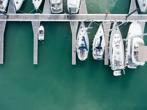 Vue aérienne d'un port avec plusieurs voiliers amarrés. Le coût de l'assurance bateau dépend de nombreux facteurs.
