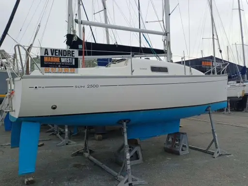 Bateau Sun 2500 à vendre, avec sa quille bleue et sa voile noire. Marine West propose ce voilier.