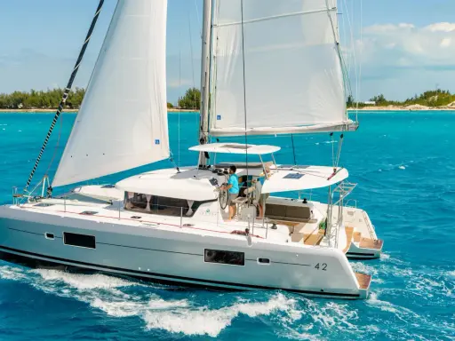 Catamaran Lagoon 42 naviguant sur des eaux turquoise. La fiche technique de ce voilier de luxe promet des croisières inoubliables.