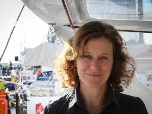 Isabelle Joschke, souriante, sur un bateau, prête pour une nouvelle aventure maritime.