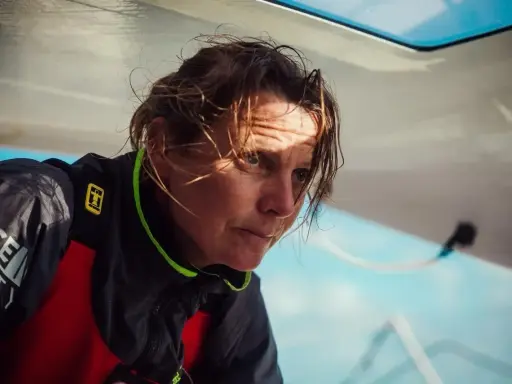 Anne Claire Le Berre, concentrée, le regard intense, le visage marqué par le soleil et le vent, sur un bateau.