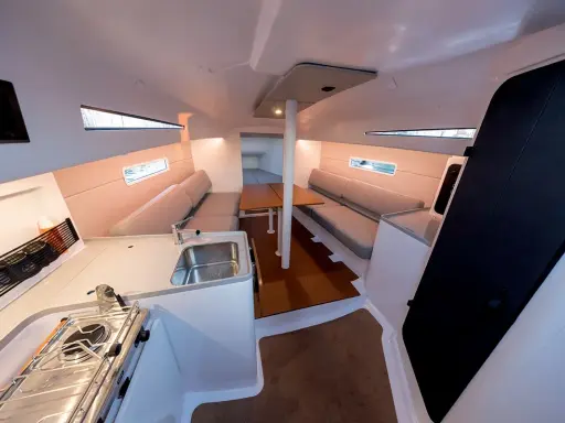 Intérieur d'un voilier moderne, avec cuisine, salon et table. Les premiers 30 pieds offrent un espace confortable pour la vie à bord.
