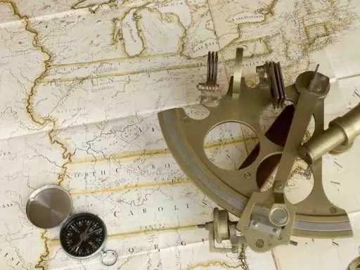 Un sextant et une boussole sur une carte ancienne, évoquant la navigation et l'exploration.