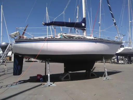 Voilier Kelt 850 blanc et gris, sur bers, prêt pour l'hivernage.