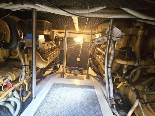 Vue de la salle des machines d'un bateau, avec deux moteurs inboard jaunes. L'entretien régulier est essentiel pour la durée de vie d'un moteur inboard.