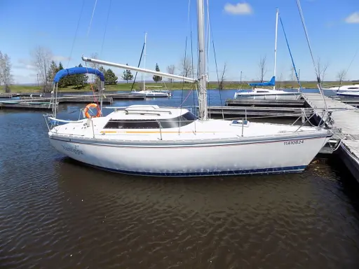 Un voilier blanc, le "Xantippe", est amarré dans un port. Ce bateau de fantasia attend de prendre le large.